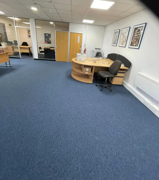 Blue carpet tiles in an open-plan office with desks