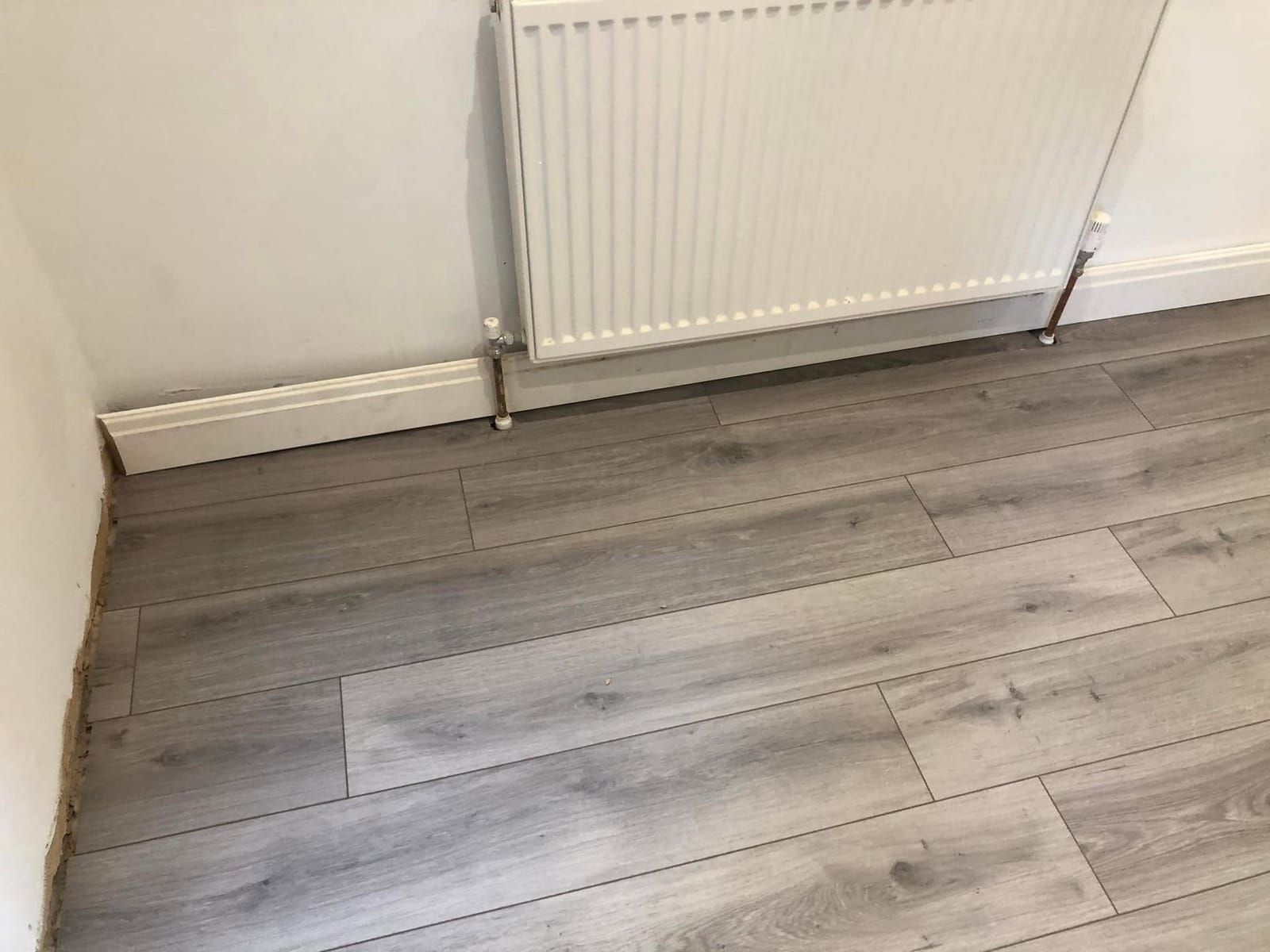 Grey oak laminate in a room with a radiator