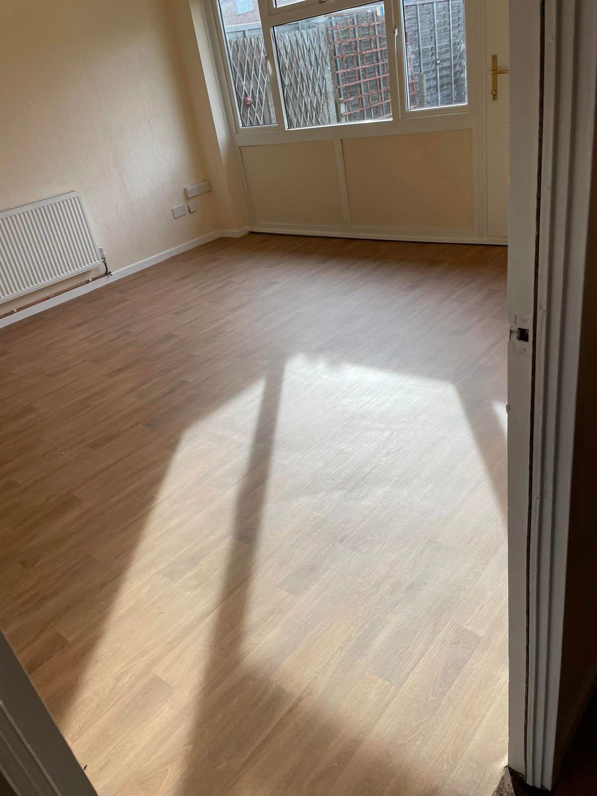 Light oak laminate in an empty room in strong sunlight