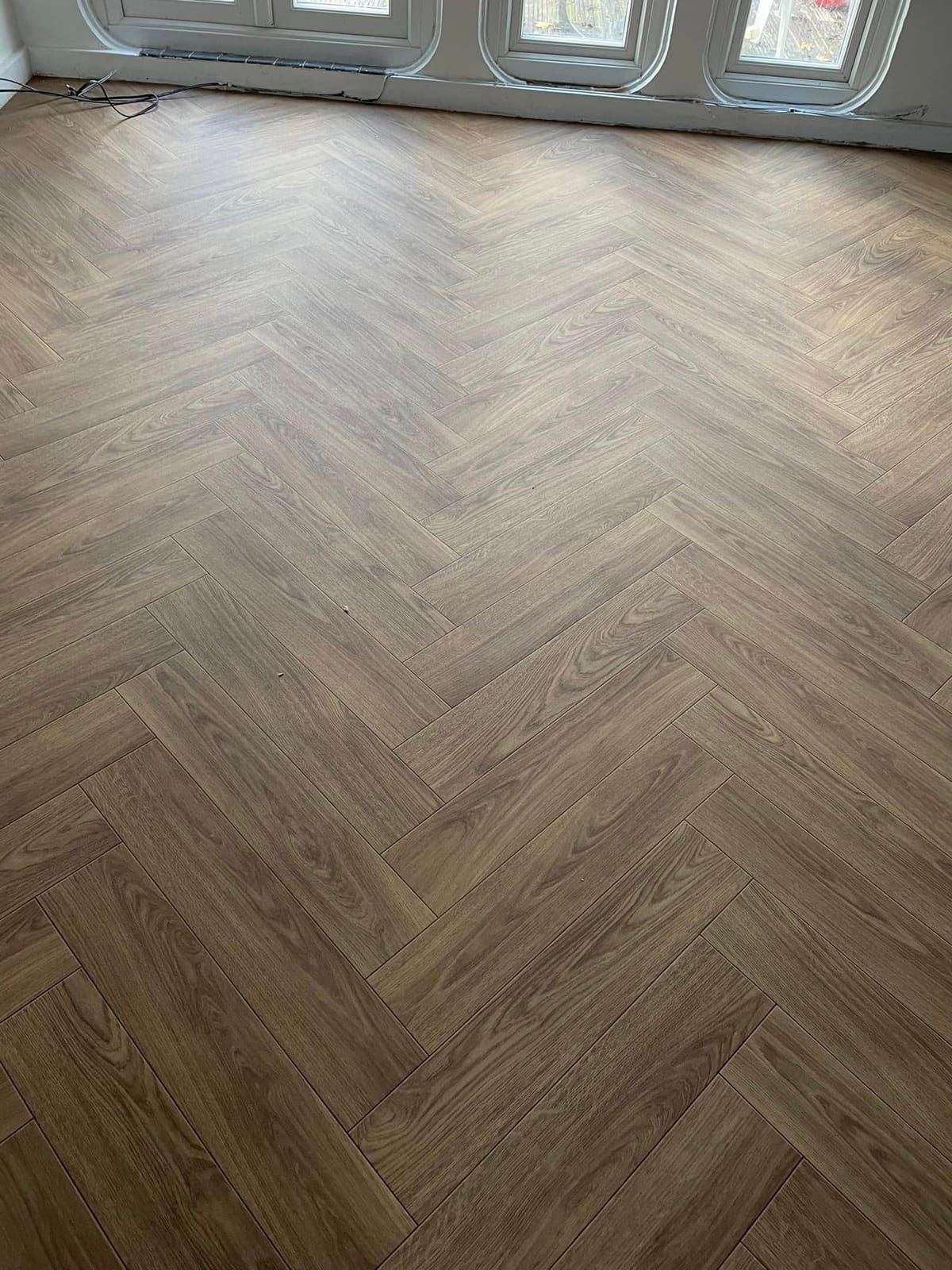 Oak herringbone LVT in a room with bay windows