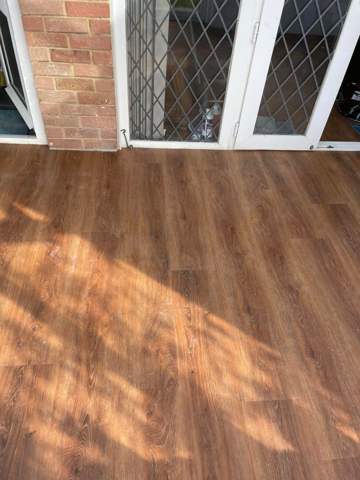 Warm oak plank floor beside leaded glass doors