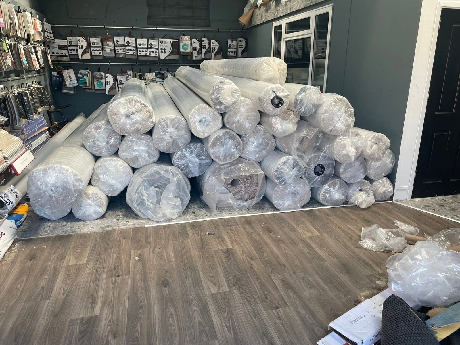 Wrapped B-grade carpet rolls stacked in the showroom