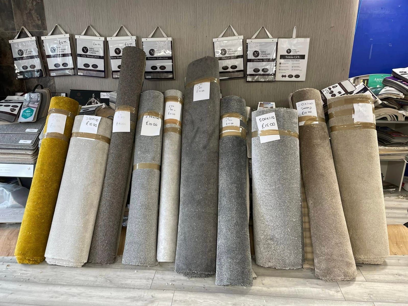 Carpet roll ends lined up with price tags in the showroom