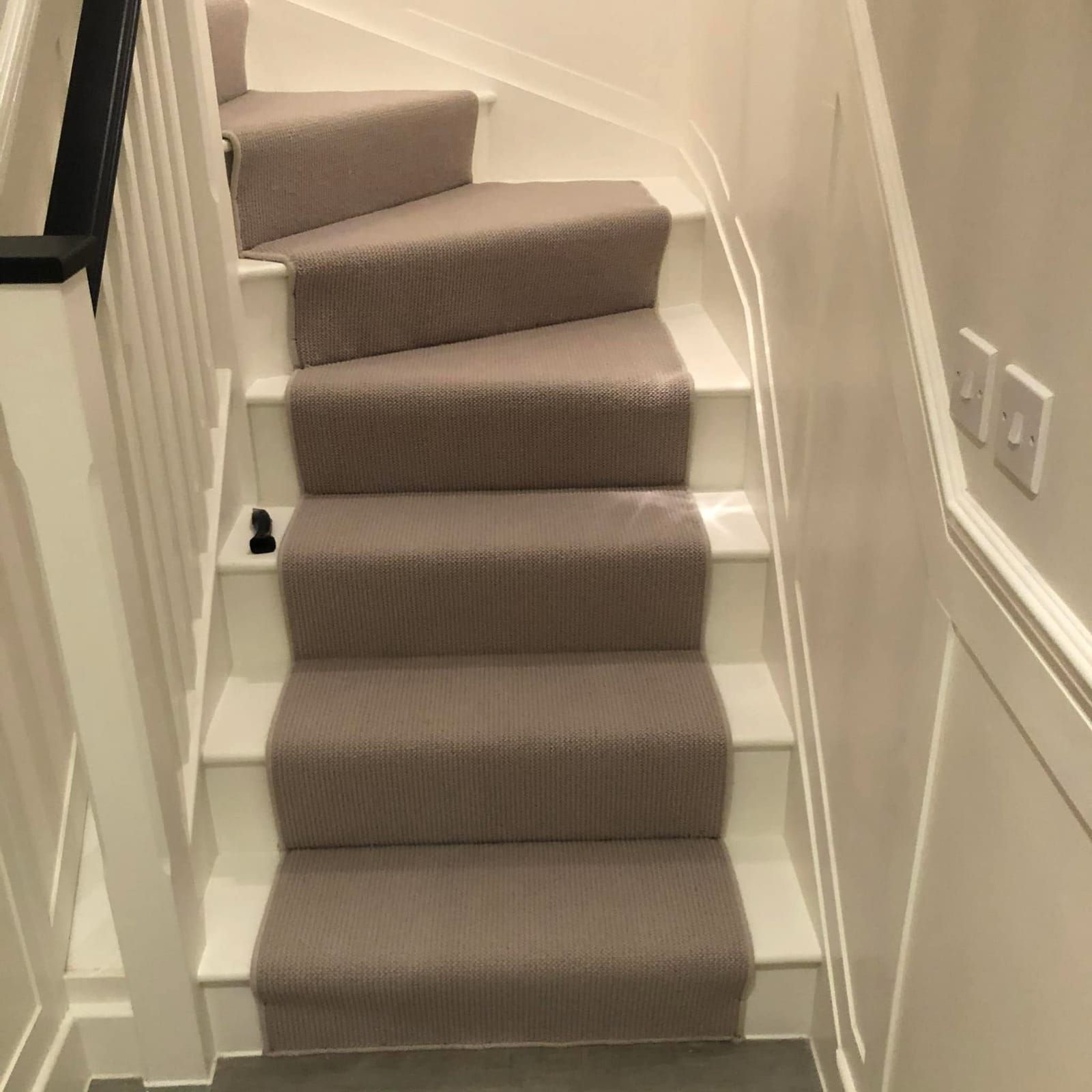 Grey runner on white painted winding stairs
